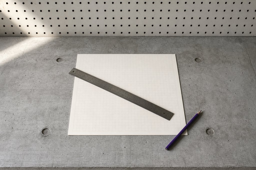 Leeres Rasterblatt mit feinen Linien, ein Stahllineal diagonal darüber, ein violetter Stift an der Ecke