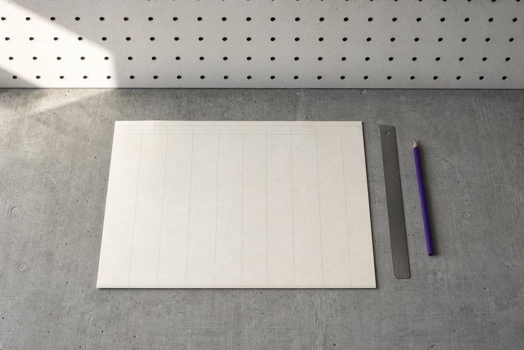 Breites leeres Buchungsblatt mit feinen Spaltenlinien, ein Stahllineal entlang einer Spalte, daneben ein violetter Stift